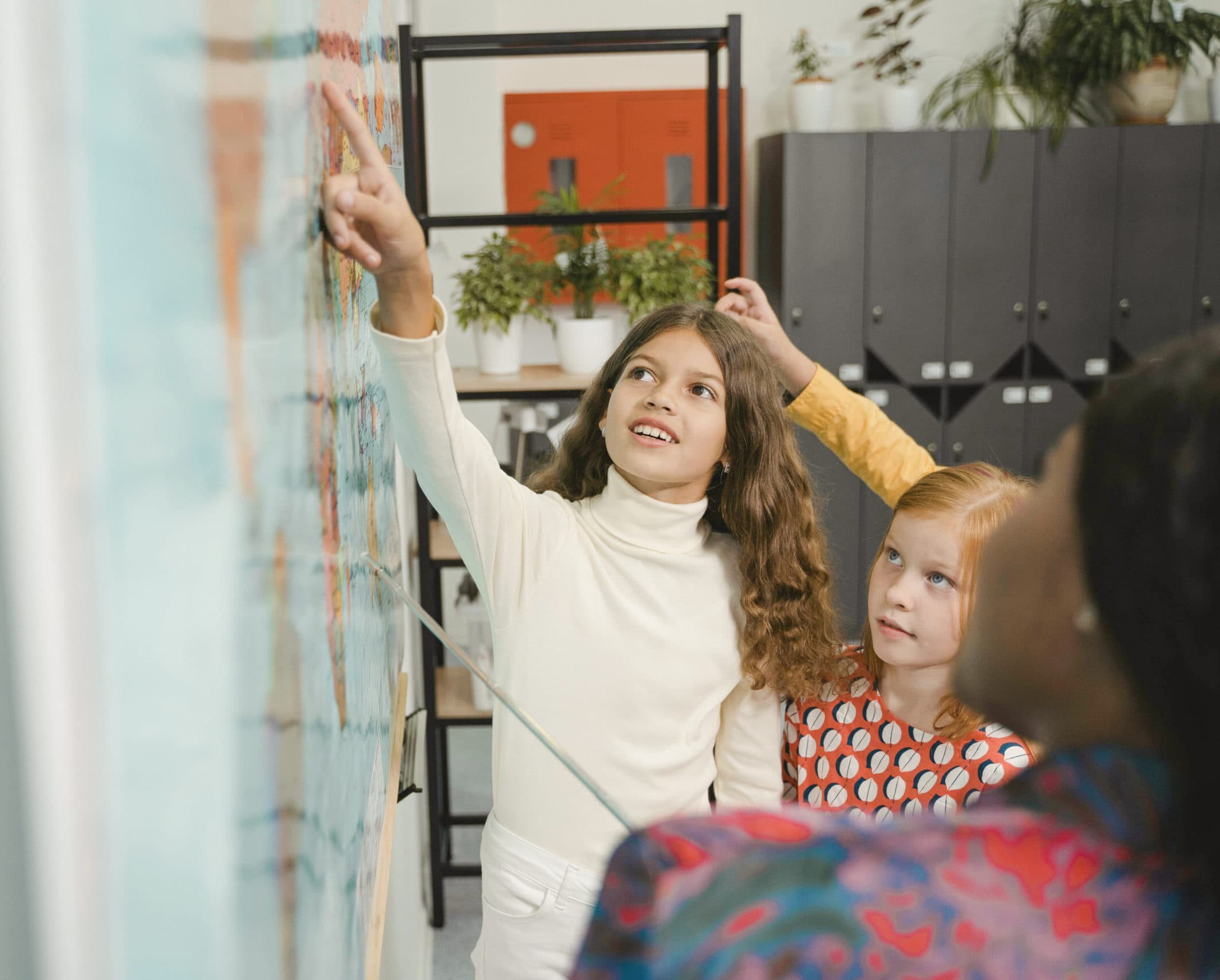 Kinder gestalten gemeinsam eine Wand mit Bildern und Notizen.